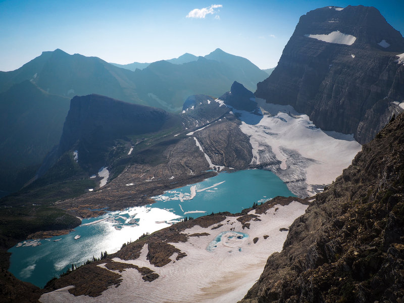 Atop the Glacier Overlook, Upper Grinnell Lake and Grinnell Glacier stand out as the dominant features. Angel Wing (left-center), Mount Gould (top-right), and Salamander Glacier (bottom) also appear.