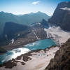 Atop the Glacier Overlook, Upper Grinnell Lake and Grinnell Glacier stand out as the dominant features. Angel Wing (left-center), Mount Gould (top-right), and Salamander Glacier (bottom) also appear.