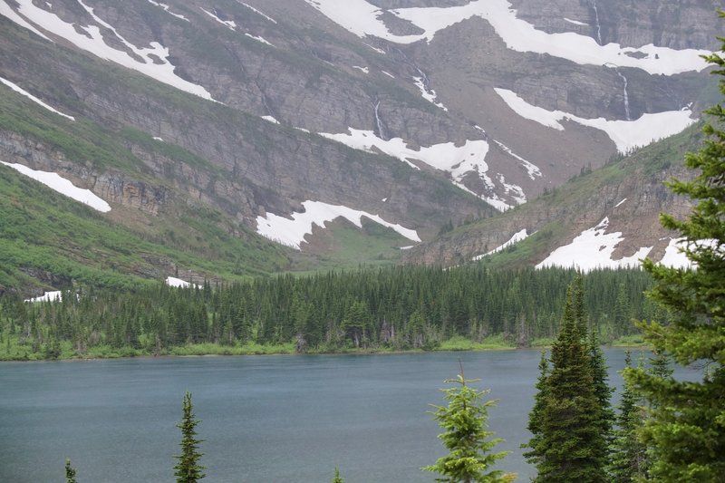 Snow and nameless waterfalls sit above Bullhead Lake on a rainy day in June.