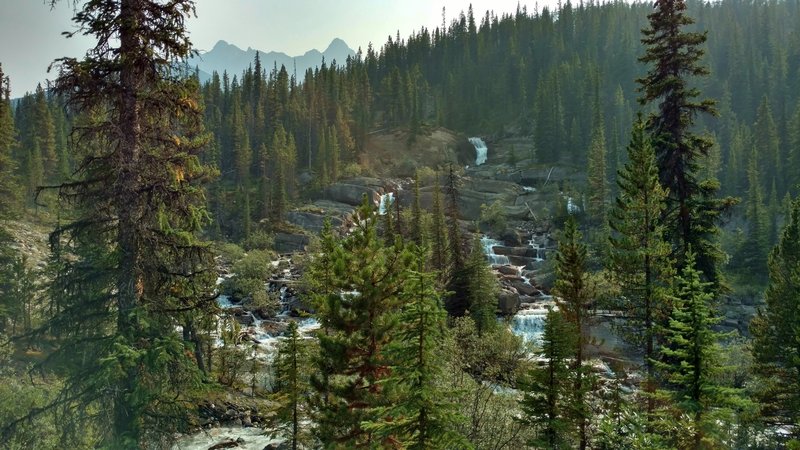 A massive waterfall along Poboktan Creek, with Waterfall Peaks looming over it in the distance, near Waterfalls Trail Camp on the Poboktan Pass Trail.