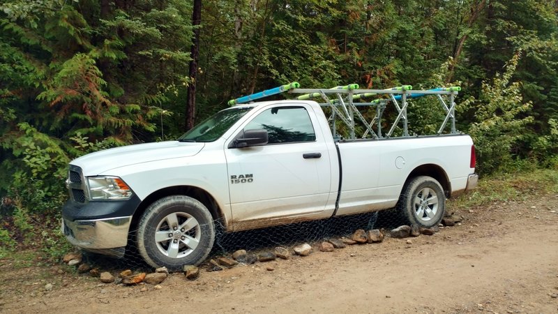 Parked truck wrapped with chicken wire to prevent porcupines from eating brake lines, etc.