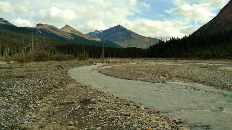 The Smoky River spread out across gravel flats, making for a lower water level and easier ford. Tatei Ridge is the mountain in the center with Chetang Ridge to its left. Seen looking upstream (southeast) at the alternate Smoky River crossing.