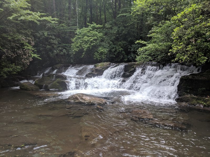 Smaller waterfall leading up to larger falls with swimming hole