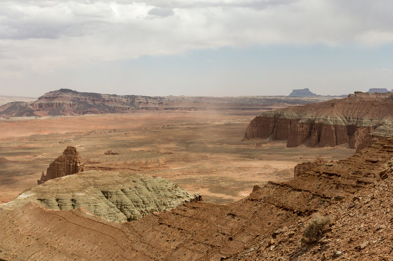 The tip of Temple of the Moon rising from the floor of Lower Cathedral Valley with Black Mountain and Factory Butte in the background.