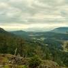 Orcas Island farm lands, Sucia and little Matia Islands, and Canada (center, near to far) and north shoulder of Mt. Constitution rises behind East Sound on the right, looking northeast from Ship Peak.