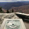 Summit plaque with directions of mountains in the distance.