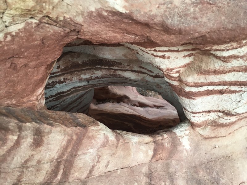A hole (or mini arch) in the wall of the canyon.