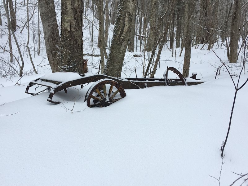 Old farm equipment or old car with wooden wheel spokes.