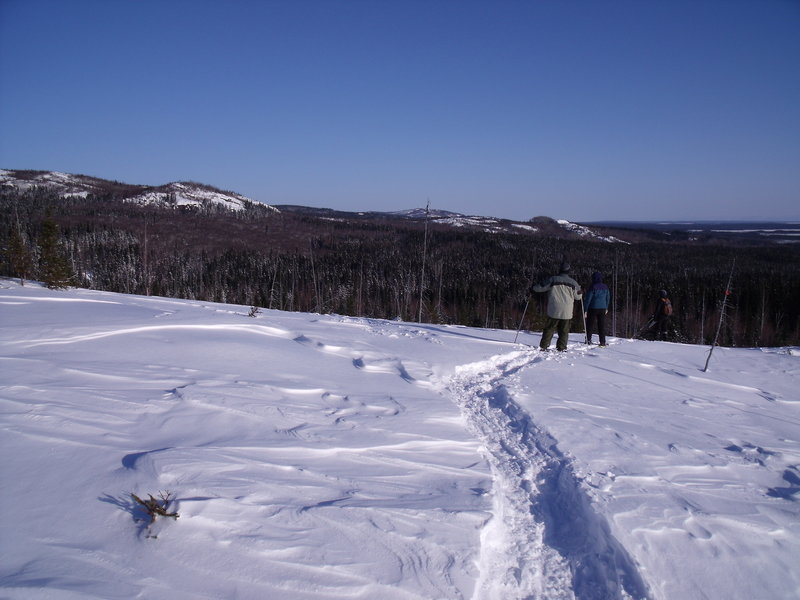 Donna, Betty Anne and Kevin on Snowshoe Trail A2 looking towards Aspen Lookout on E2 and the knoll that is scaled by Snowshoe Trails E3 and D6.