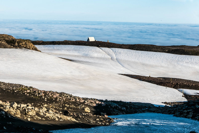 The Fimmvörðuháls / Baldvinsskáli hut in the distance above the cloud cover.  There is another hut named Fimmvörðuháls which is VERY confusing.  Be sure you know which one you are staying in because the wrong choice could add 1 hour of hiking.