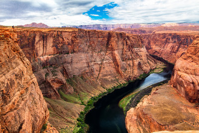 The canyon is bigger than I imagined. For scale, you can see a person sitting on the ledge on the left side.