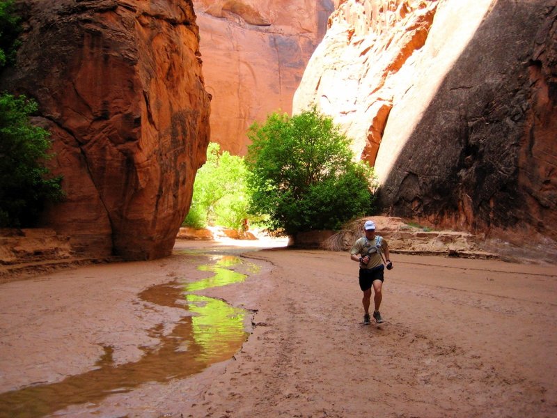 Chris runs past the large, open "chamber" near the end of Buckskin Gulch. There is a campsite here, but reservations are required years in advance.