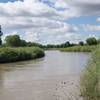 The Arkansas River runs next to the fort. After an evening of thundershowers, the river runs higher than normal.