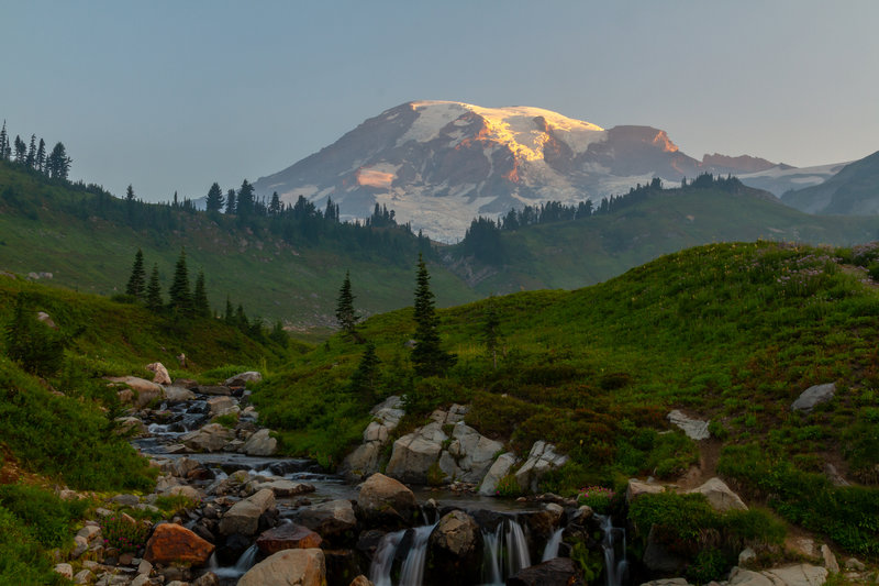 Looking up to Mount Rainier at sunrise from the bridge above Myrtle Falls.