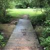 The wooden bridge into the clearing with benches.