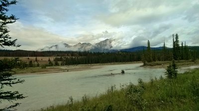 A side channel of the Athabasca River with Pyramid Mountain in the distance (center) partly hidden in the clouds, looking northwest from the Athabasca River Trail.