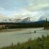 A side channel of the Athabasca River with Pyramid Mountain in the distance (center) partly hidden in the clouds, looking northwest from the Athabasca River Trail.