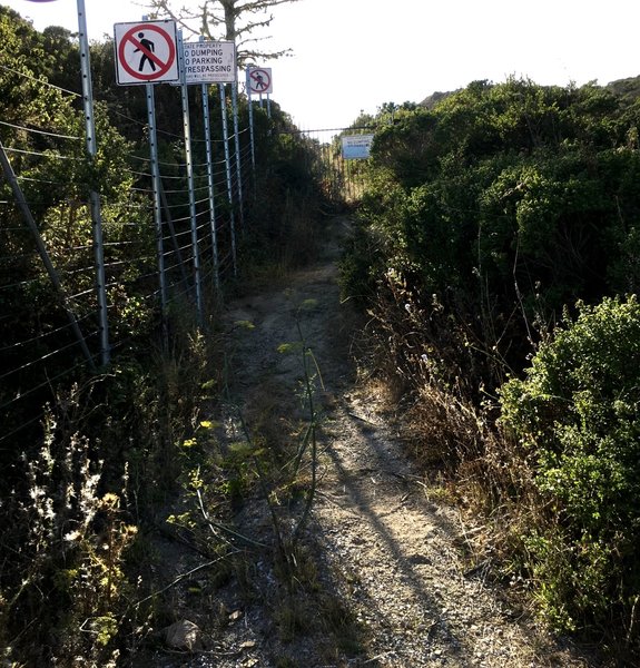 Access to trail around black gate is blocked by wire fence