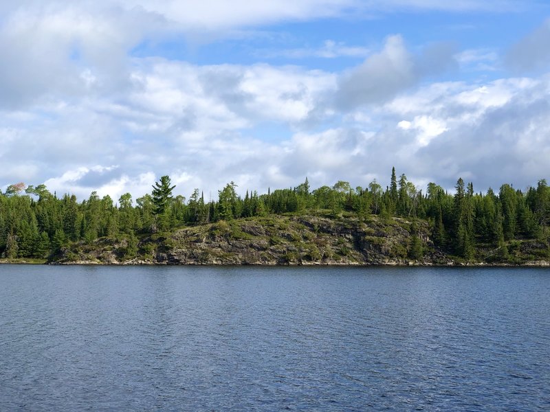 Standing on the south shore looking onward to the cliffs of Locator Lake at the end of Locator Lake trail.