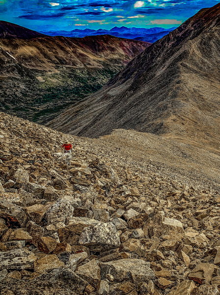 Top of the false summit of Mount Democrat looking down at the saddle and trail up to Mount Cameron. That nice lady with a floppy hat is 79 years young and this was her fifth time to complete Decalibron Loop! For scale, zoom to center, below her.