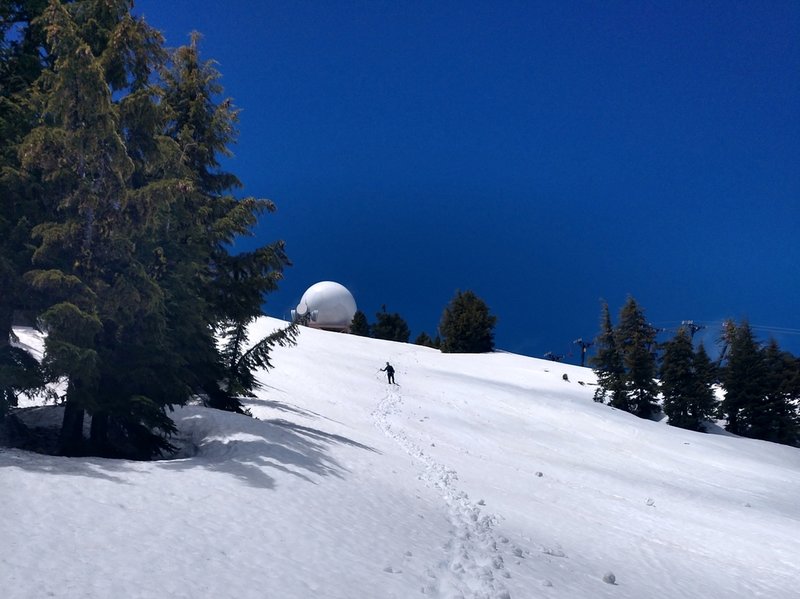 Descending the trail in early season when the ski area is closed but there's still snow cover up high