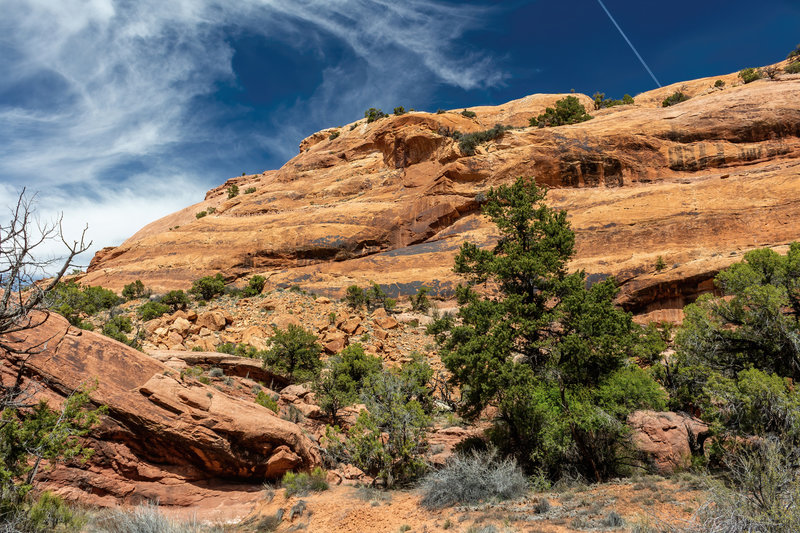 The sandy loop trail slowly descends further between towering rock walls.