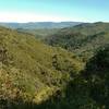 Nearby are the wooded and brush covered hills of Rancho Canada del Oro Open Space Preserve, with the trail far below. In the far distance across Coyote Valley, is the Diablo Range, seen looking east from high on Longwall Canyon Trail.