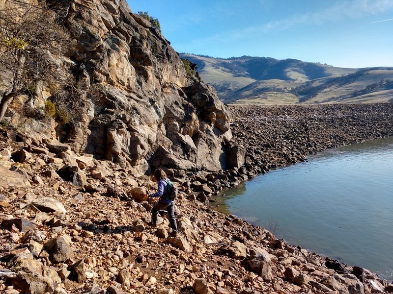 Scrambling below the cliff to the dam beyond (low water route)