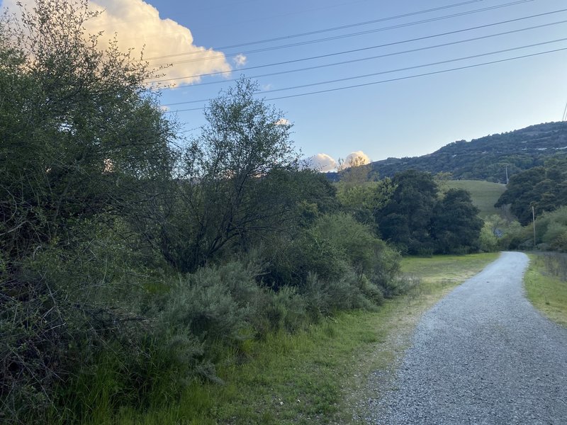 The trail turns to gravel and descends below the reservoir to the area where water drains out and the spillway is.