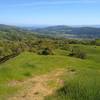 Center left, very far distance is Monterey Peninsula. In front of it in the distance is Anderson Lake in Santa Clara Valley below these Diablo Range hills. Blue Santa Cruz Mountains, and San Felipe Creek Valley and its west ridge (right distance).