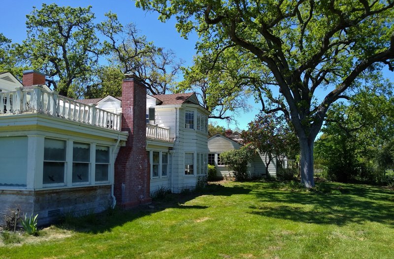 The historic Ranch House (left foreground), Cook House (left background), and Ranch House lawns can be explored from Grant Trail.