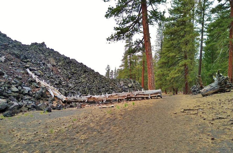 On the left is a close up look at the black boulders of the Fantastic Lava Beds, as Nobles Emigrant Trail (East) runs next to them. These large boulders were formed by slow cooling lava from Cinder Cone.