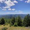 View from the top of Cedar Butte, trees and mountains extending away into the distance.