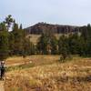 Wooded area opens up revealing dramatic cliffs.