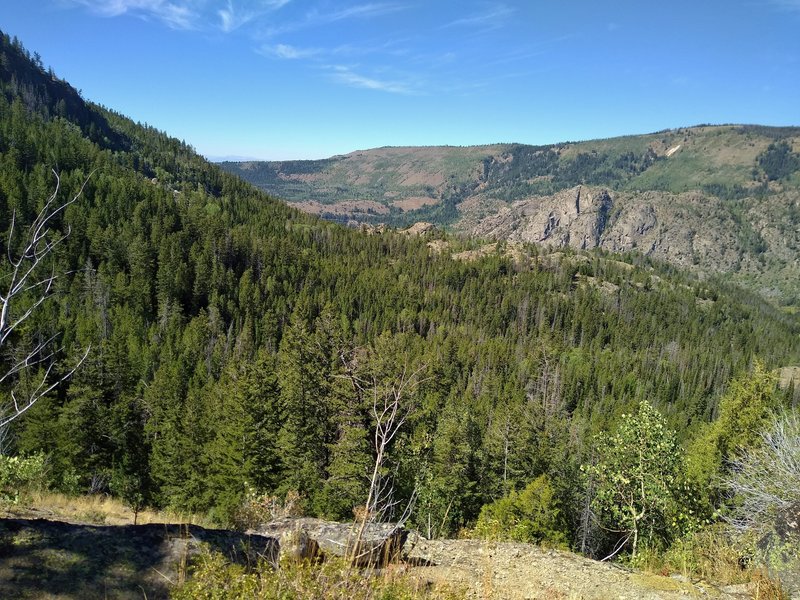 The far side of Pine Creek's Canyon is seen in the distance, across Pine Creek Valley when steeply descending into the valley on Long Lake Trail.