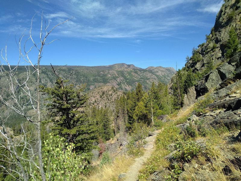 Long Lake Trail descends on the steep eastern side of Pine Creek Canyon, with views of the western side of Pine Creek Canyon in the distance across Pine Creek's valley.