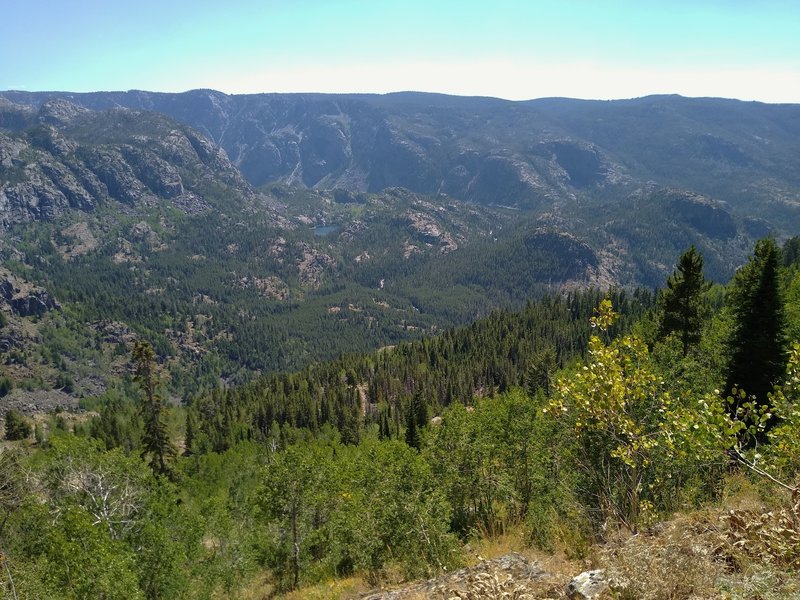 Triangle Lake (center left) is far below to the east-southeast. The valleys below the distant highlands, hold the creeks and lakes of the Pine Creek drainage. Photographers Point is behind Triangle lake on the far ridge top. Seen just below the lookout.