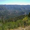 Triangle Lake (center left) is far below to the east-southeast. The valleys below the distant highlands, hold the creeks and lakes of the Pine Creek drainage. Photographers Point is behind Triangle lake on the far ridge top. Seen just below the lookout.