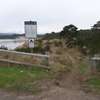 Trailhead of the Bay Trail with a sandy track passing between two wooden fences.