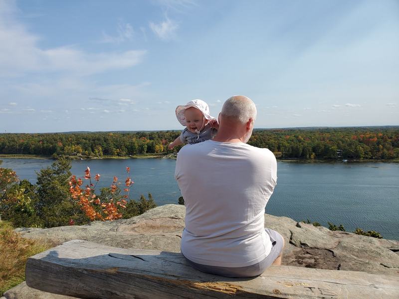 Dad and baby on a bench overlooking the St. Lawrence River