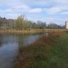 Fall view of pond with train tracks and silo in background.