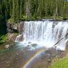 The plentiful mist thrown up by Iris Falls make beautiful rainbows a frequent part of the view. Flower and wild onions grow on the canyon rim just off the trail.