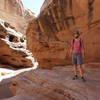 Hiker posing on a shaded slickrock ledge in Bell's Canyon.