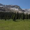 The meadow backed by rocky peaks taken from the picnic tables in front of the Stanley Mitchel Hut.