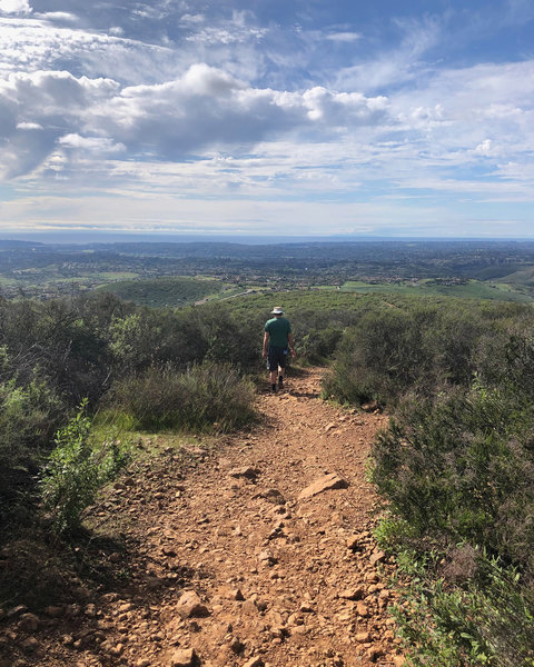 Hiker on Black Mountain, facing toward the Santaluz Club with Rancho Santa Fe in the far background.