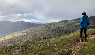 A hiker standing on top of the Moab Wall.