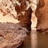 This narrow section is located between the first and second falls. Unless the water levels are unusually low, you'll have to swim for about 100 ft to get through. We went through in mid March and the water was about 5.5 feet deep.