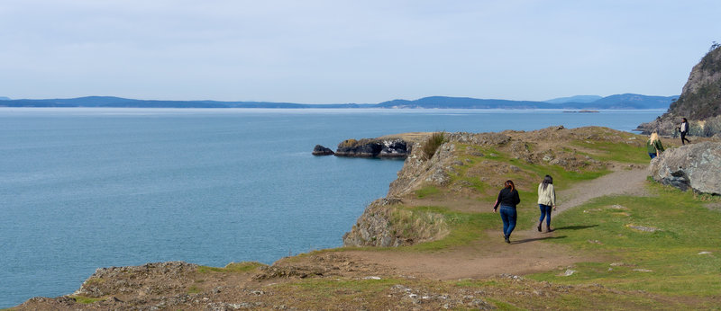 Hikers walking along the cliffs of Rosario Head