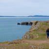 Hikers walking along the cliffs of Rosario Head