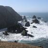 Waves hitting rocks visible from trail.